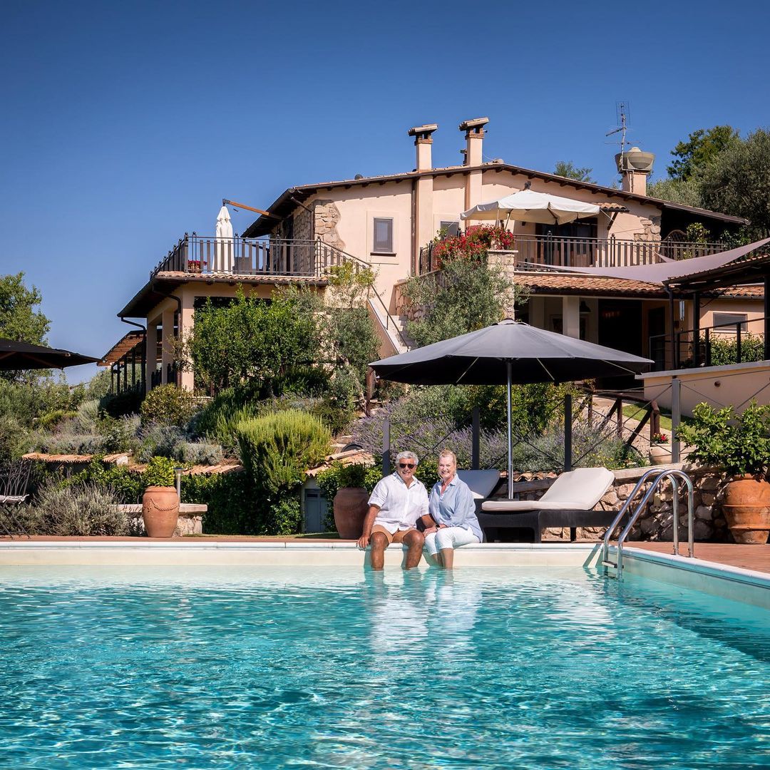 Joe and Alana sat by the pool with the beautiful Casale on the background.